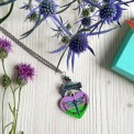Collana artigianale cuore con libellula blu-verde-viola, tartan scozzese e frase “Dinna Fash Sassenach”.