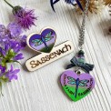 Collana artigianale cuore con libellula blu-verde-viola, tartan scozzese e frase “Dinna Fash Sassenach”.